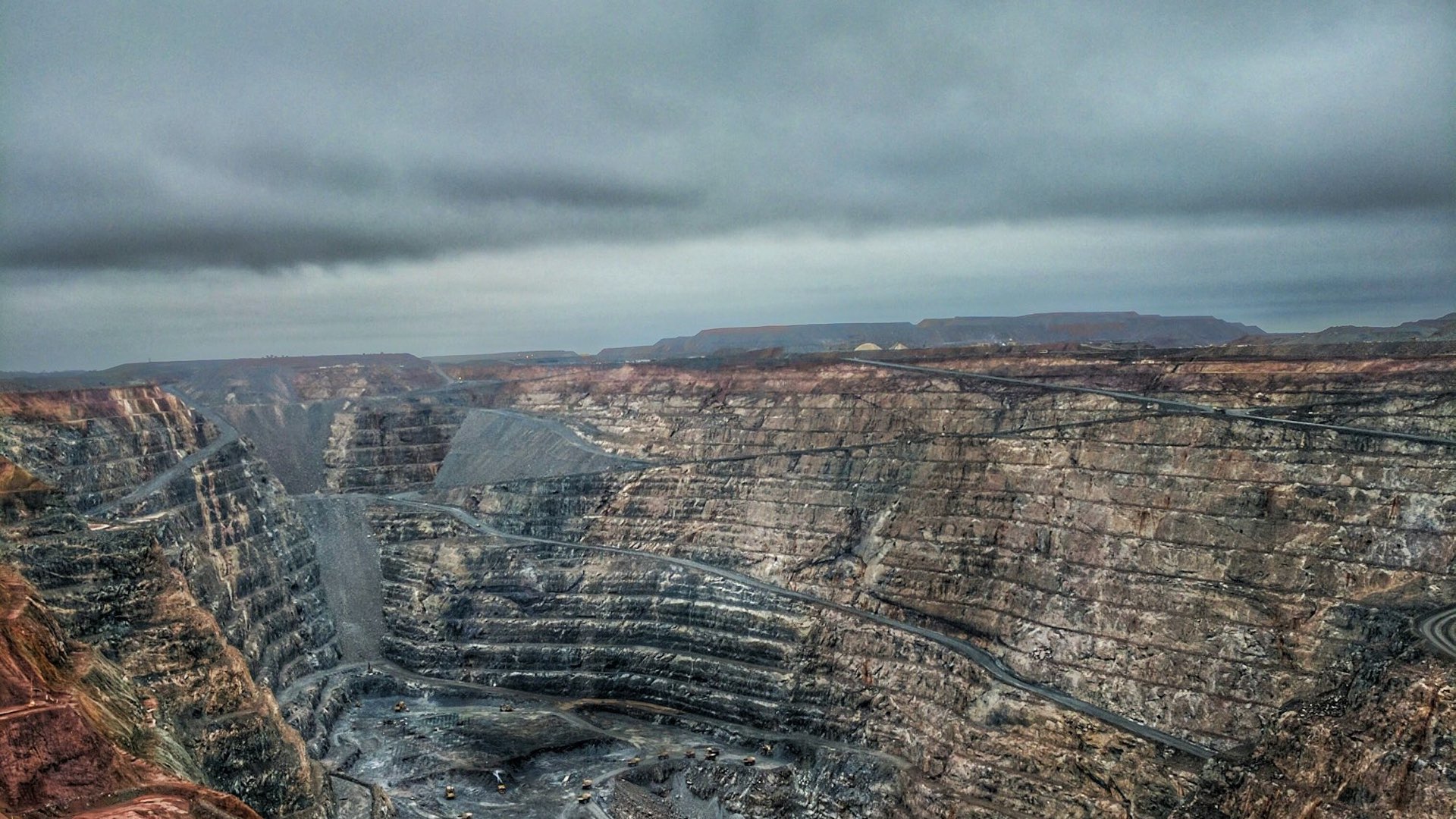 Large open-pit mine under a cloudy sky