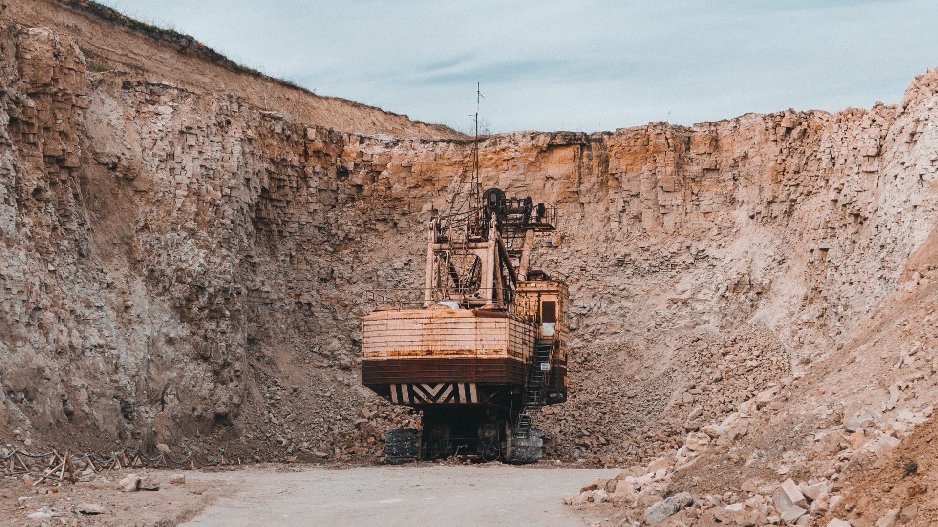 Excavator working at the face of an open-pit quarry